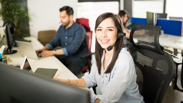 155 Portrait Pretty Young Latin Woman Wearing Headset Sitting Her Office Desk With Coworkers Background Verkleinert